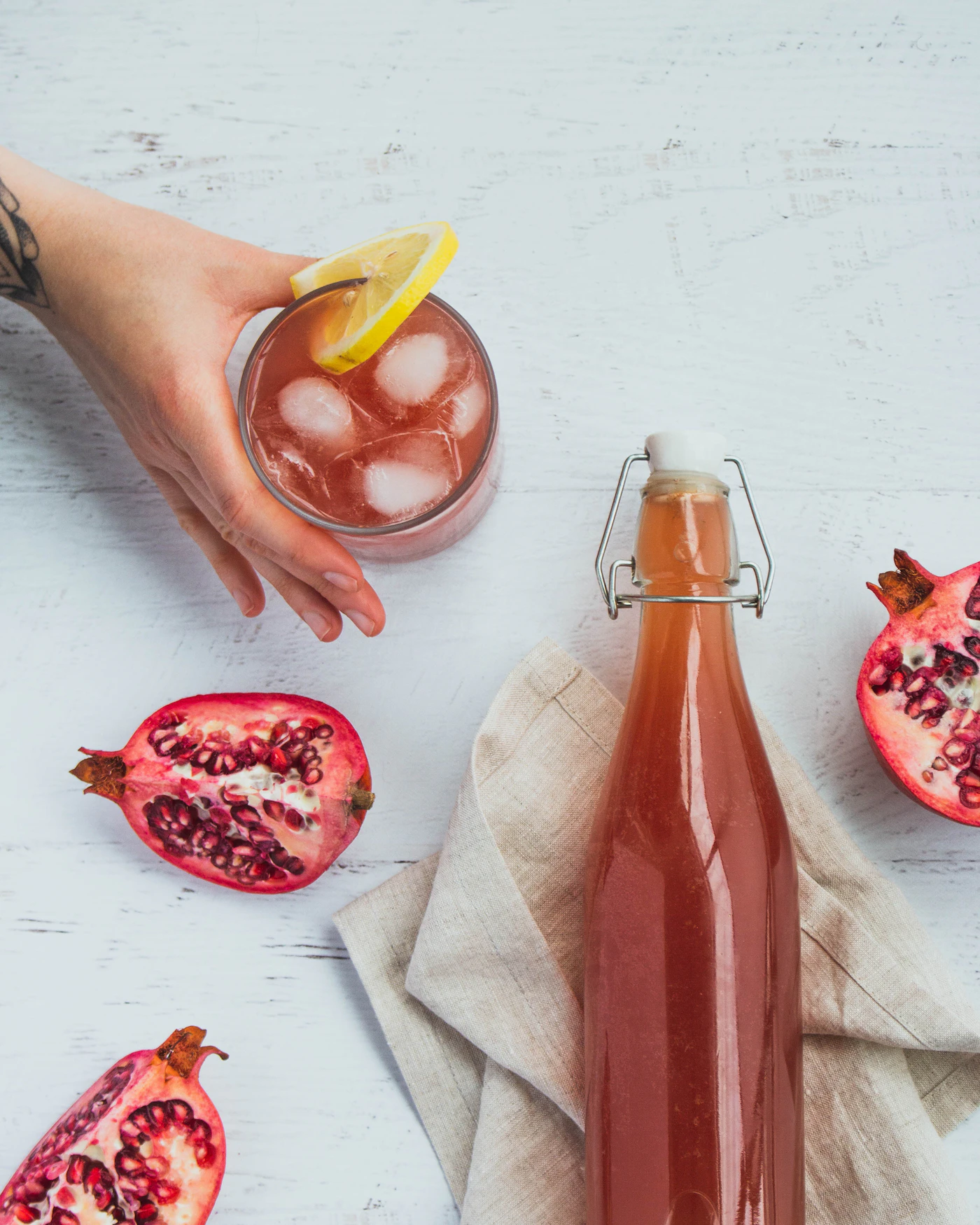 Pomegranate juice in a clear glass beside fresh pomegranate